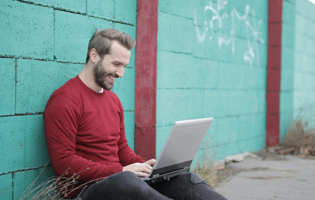 man using laptop outdoors