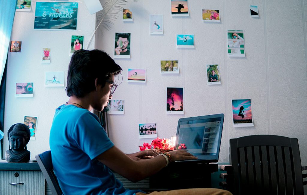 person using laptop and pictures on the wall