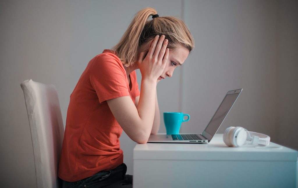 concerned looking woman using laptop